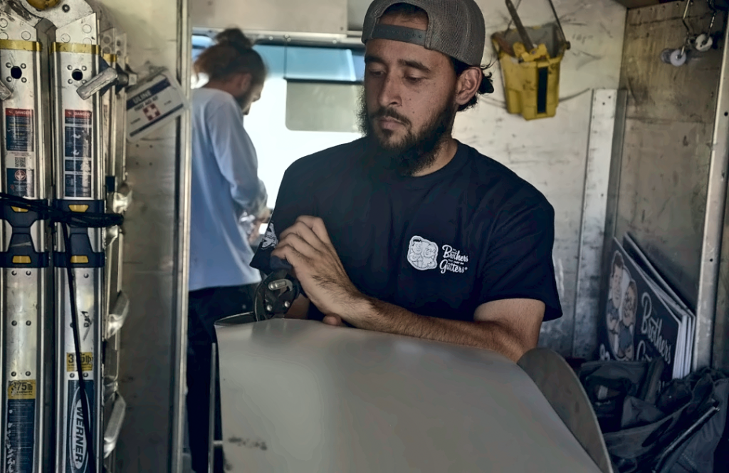 A Solutionist running a seamless gutter through the forming machine