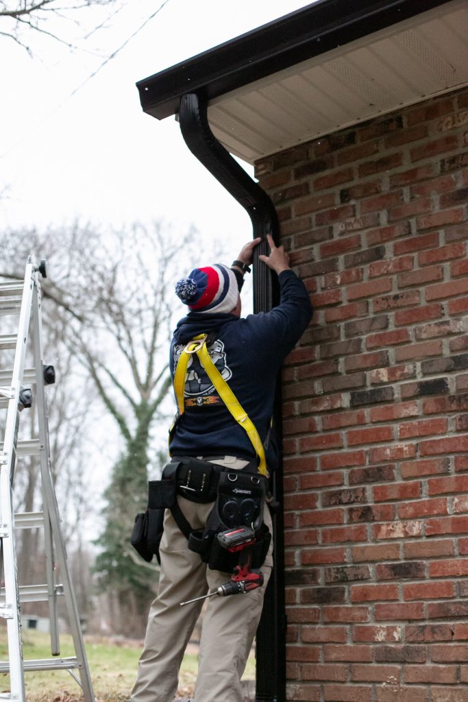 Setting a downspout bracket at a brick corner