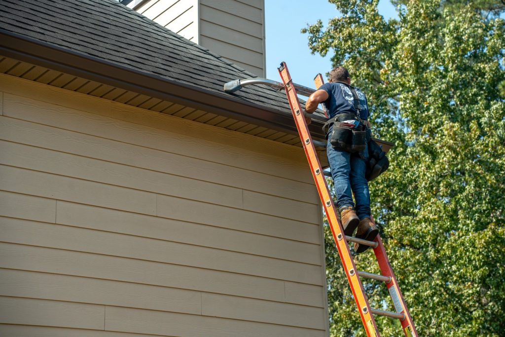Climbing to the roofline to set a new gutter