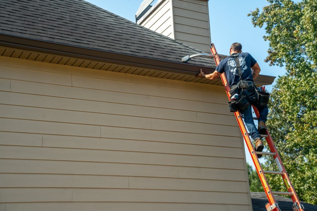 Climbing to the roofline to set a new gutter