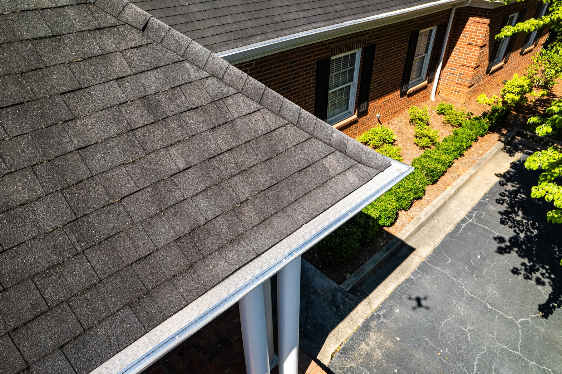 New white gutters with metal guards installed along a roofline