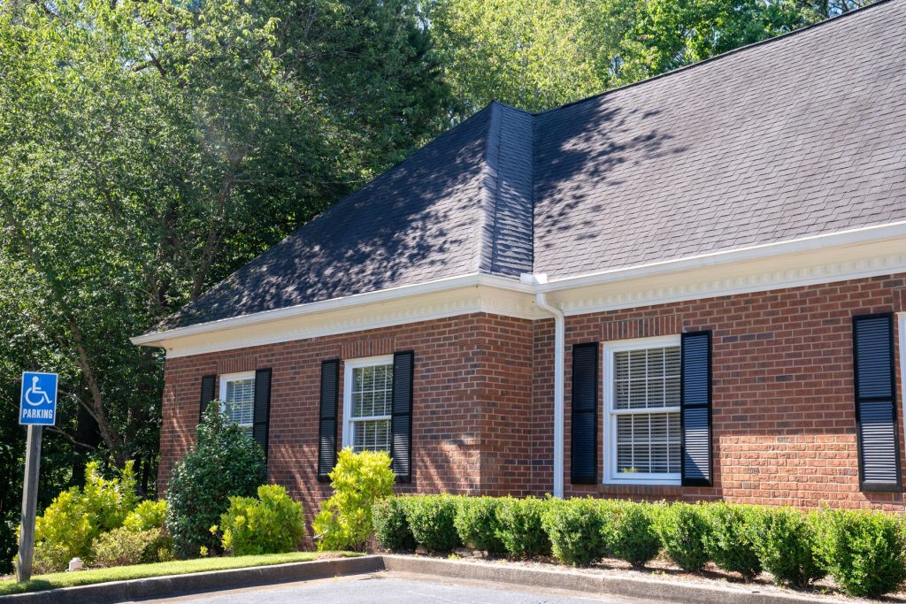 White gutters on a brick building with dark shutters